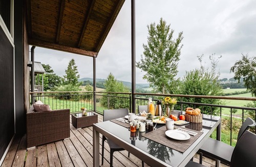 Bohmzwiesel Apartment | Ferienchalet mit überdachter Veranda mit Lounge Möbel und Schwebeliege.