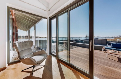 Waase Apartment | FISCHER:IN Vacation Rental in Ummanz. Panoramic sauna with a stunning view of the water. Spacious sun deck for relaxing vacation moments. The ultimate in sleeping comfort with box-spring beds. Insect Screen