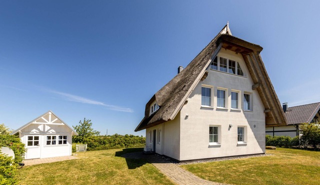 "Küstenperle" Vacation Home in Dranske – enjoy a dream vacation with a breathtaking view of the Bodden and the Baltic Sea. Child-friendly amenities, as well as a wellness area with a sauna and hot tub.